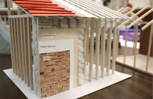 mock building made of balsa wood showing the exterior siding layers of a building