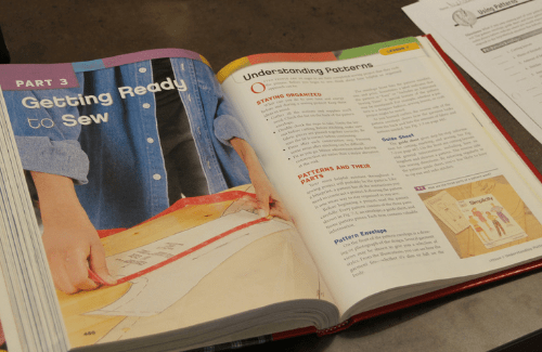 Open book with instructions for learning how to sew